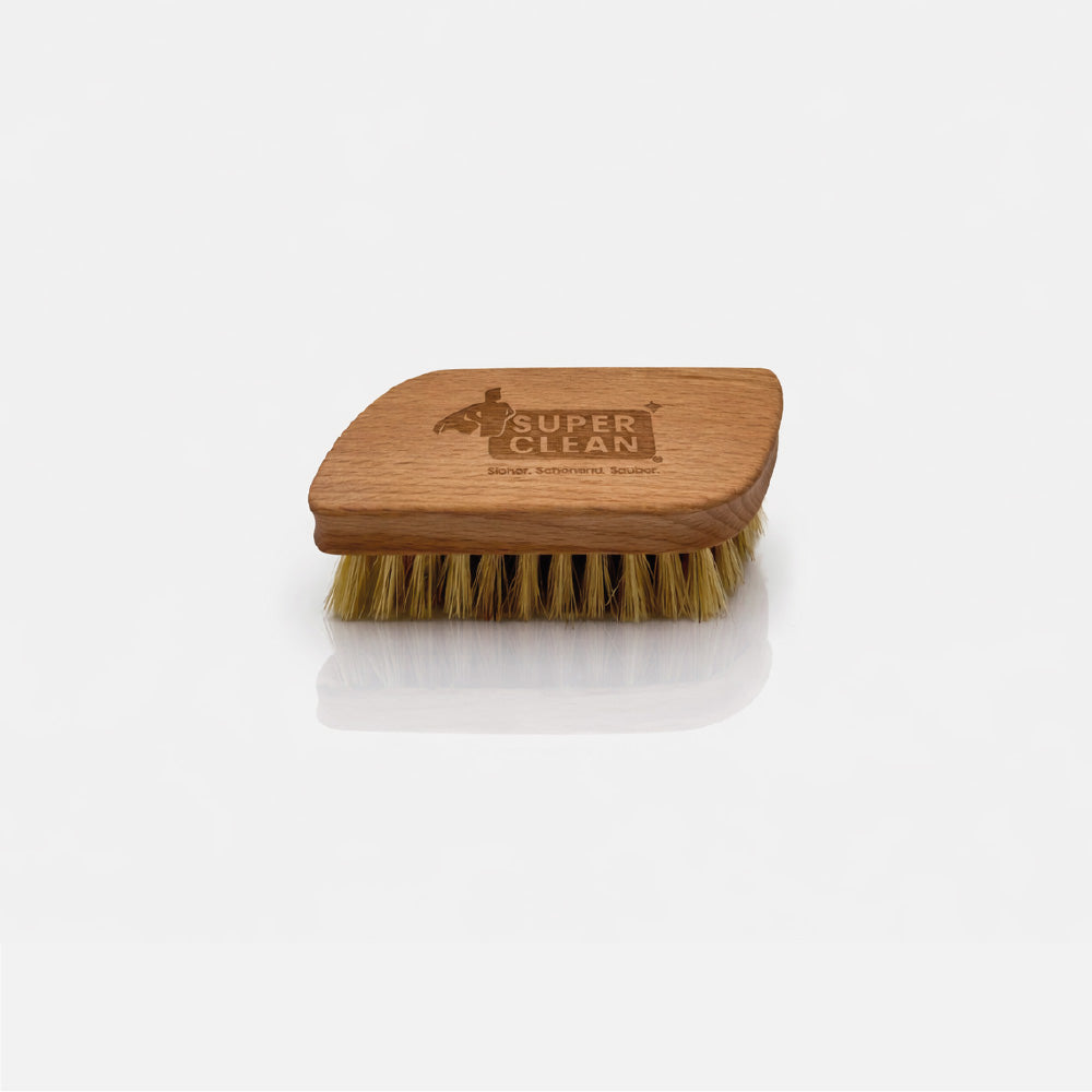 SUPER CLEAN Sneakerbürste aus Holz mit Naturborsten und Logo-Gravur vor hellgrauem Hintergrund